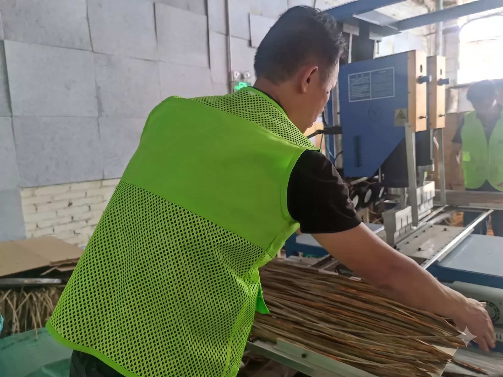 Strip alignment station — synthetic thatch bundles fed before panel forming